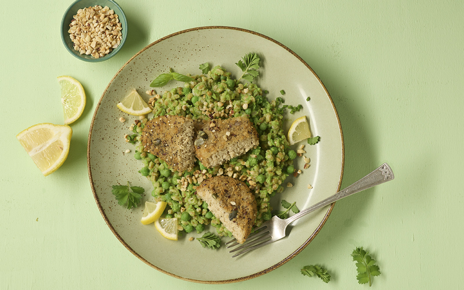 Veganes Knusperschnitzel mit Erbsen-Dinkel-Risotto und Haselnüssen