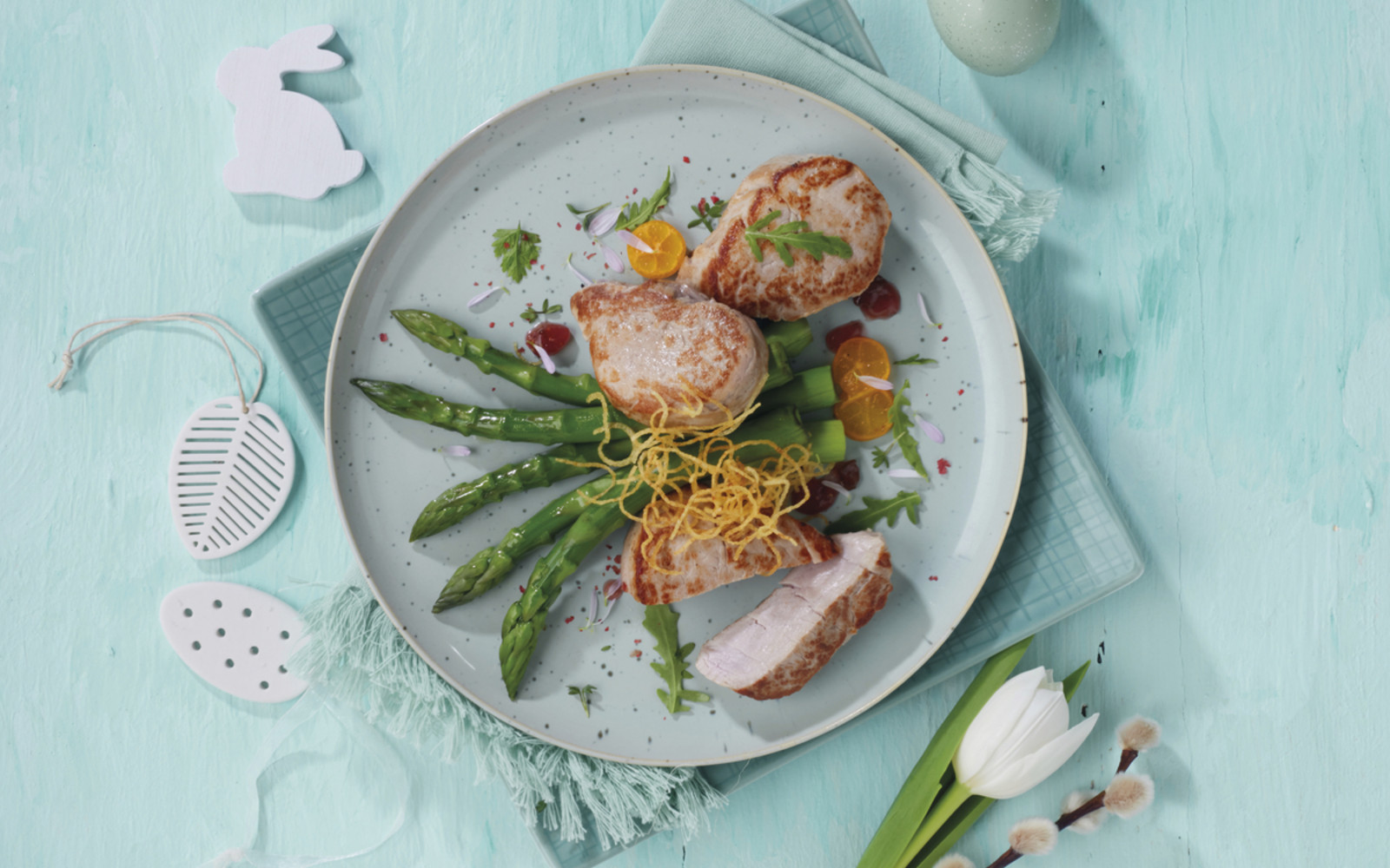 Zarte Schweinemedaillons auf grünem Spargel