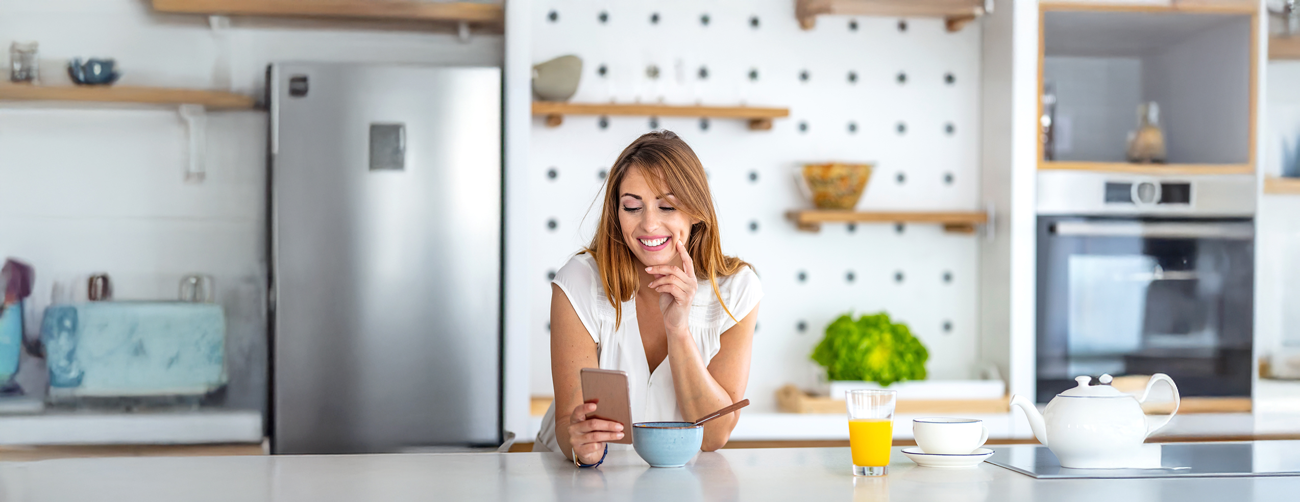 Frau mit Smartphone in Küche