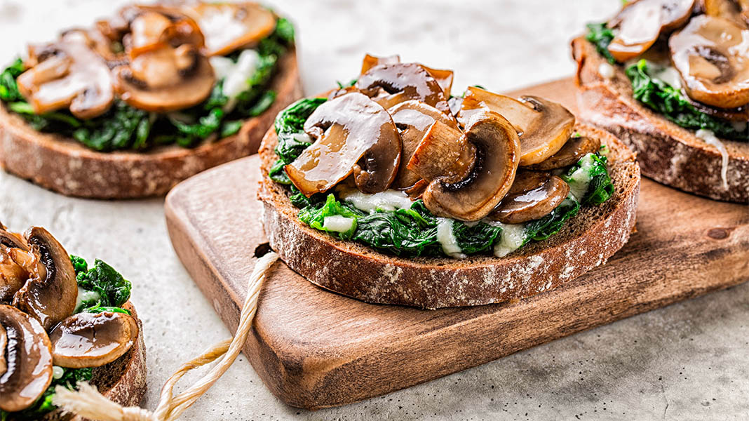 Spinat auf Röstbrot mit gebratenen Champignons