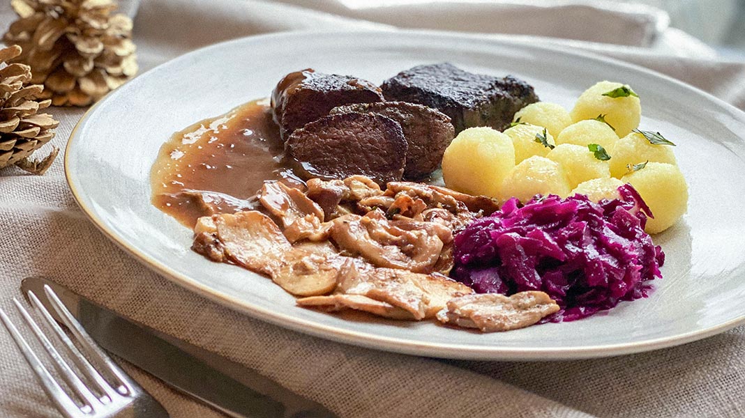 Marinierte Hirschrückensteaks mit Steinpilzen, Apfelrotkohl und Mini-Kartoffelklößen